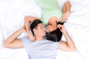 Couple lying together, gazing into each other's eyes.