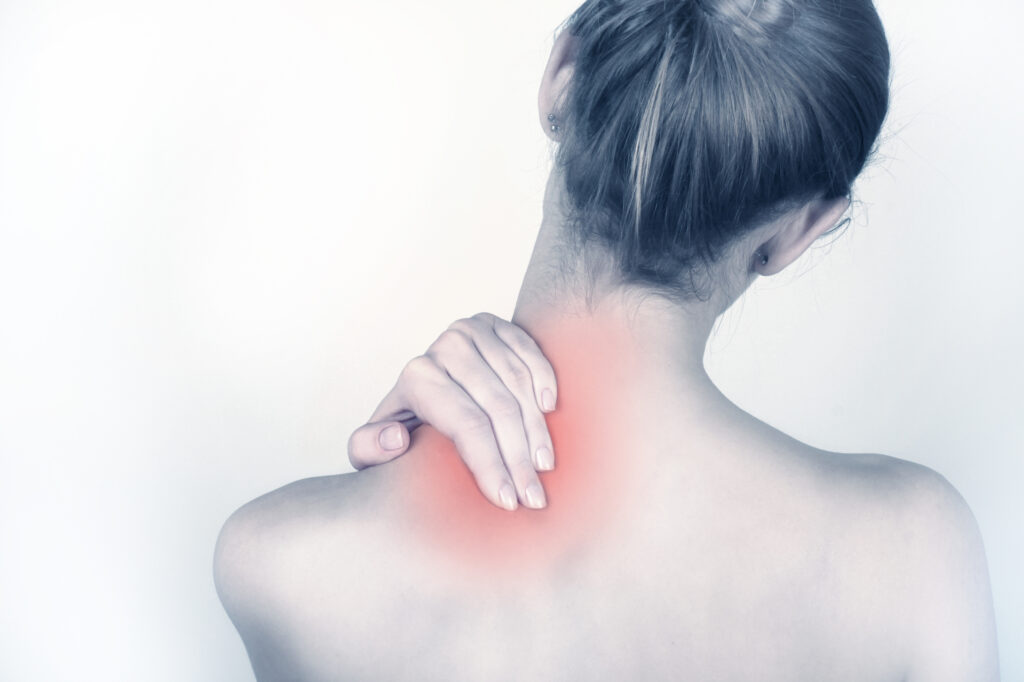 Woman holding back of neck with highlighted pain area indicating discomfort or muscle strain.