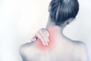 Woman holding back of neck with highlighted pain area indicating discomfort or muscle strain.