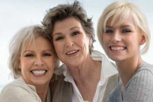 Three smiling women of different ages.