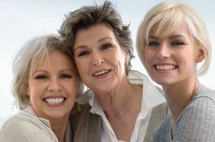 Three smiling women of different ages.