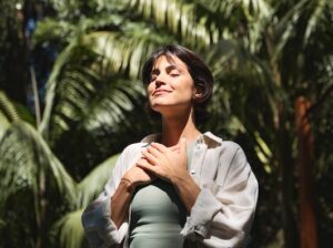 Immunity Defense IV therapy option. Woman smiling with eyes closed outdoors.
