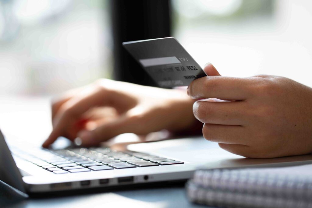 Person holing a credit card and entering it into computer.