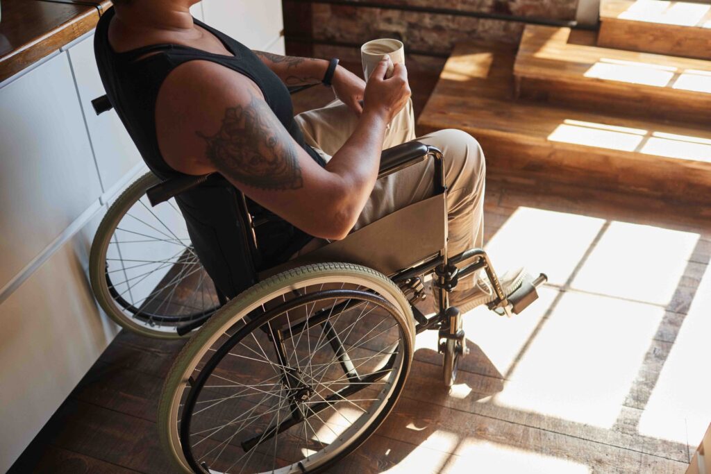 Person in wheelchair holding a mug.
