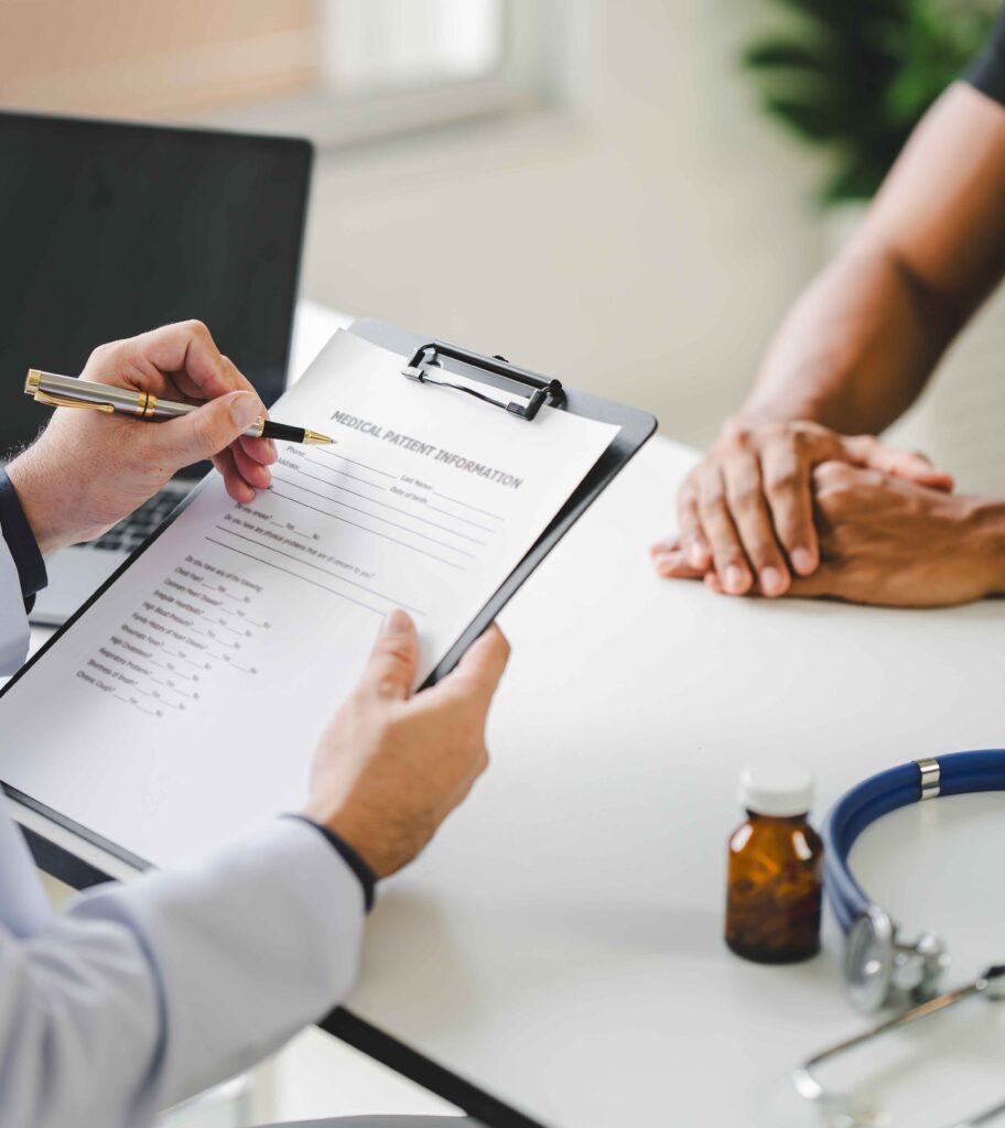 Doctor writing on a medical form with patient.