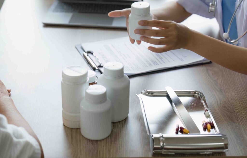 Doctor holding supplement containers explaining to a patient.