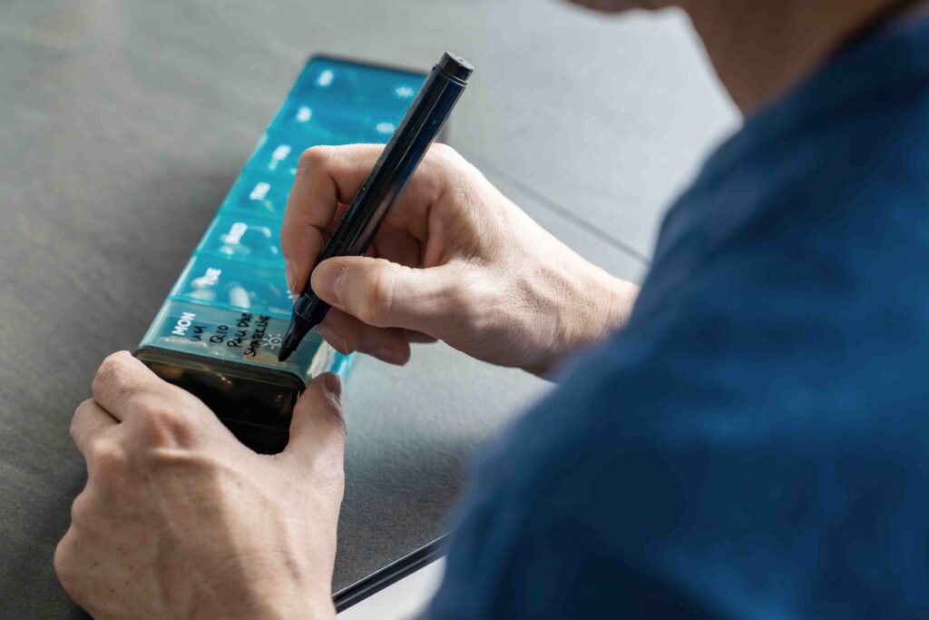Doctor marking medicine container with pen.