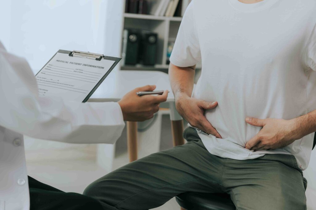 Patient touching stomache area to indicate digestion issues.