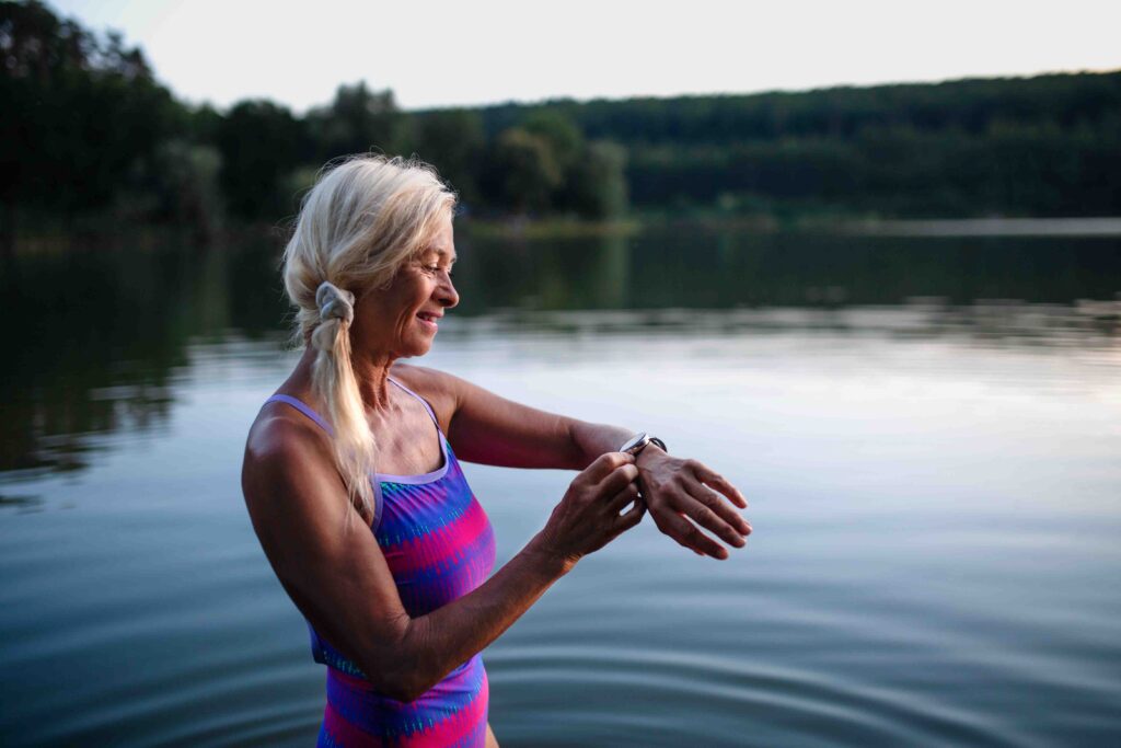 Woman about to go for a swim in a lake.