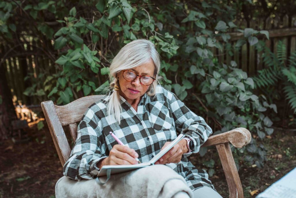 Older woman writing in her journal.