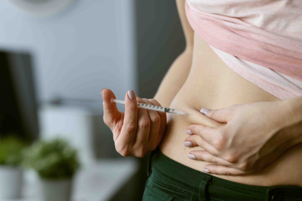 Woman doing GLP-1 injection on her waist.