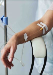 Person's arm with IV therapy tubes.