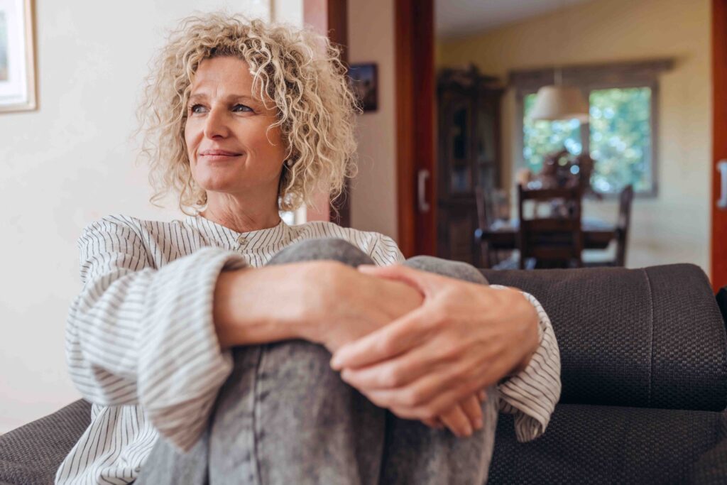 Middle-aged woman sitting down and smiling.