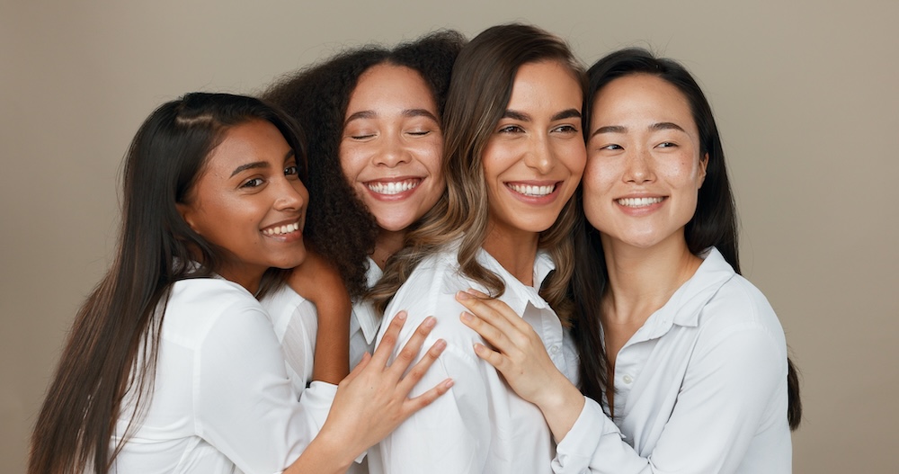 Beauty shot of 4 women smiling.